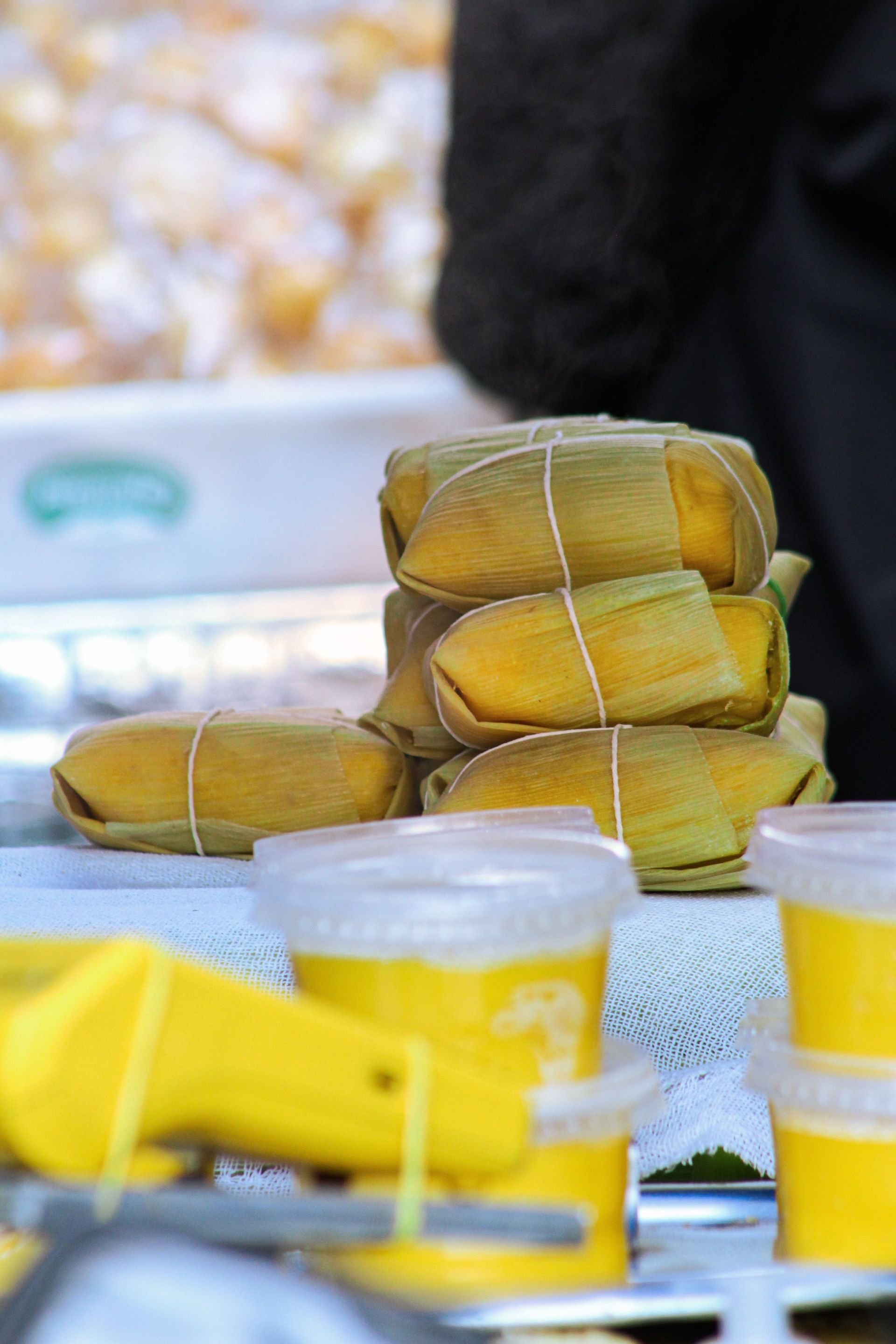 Close-up of stacked pamonha with sweet corn paste cups, showcasing traditional Brazilian cuisine.